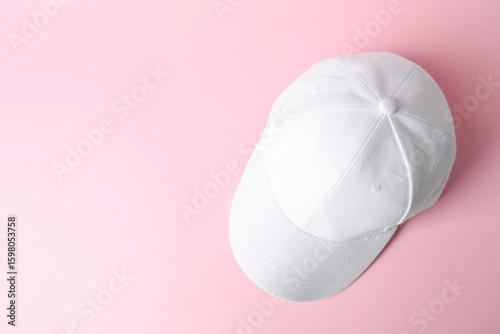 White baseball hat on pink background, top view. Space for text
