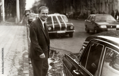 Vintage portrait of young man groom before wedding near car decorated with wedding decorations.