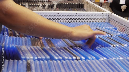 Man choosing games for console in media store, buying a compact disc in a music store, pc game shop.