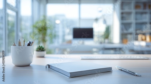 A minimalist modern office desk with natural light and blurred surroundings