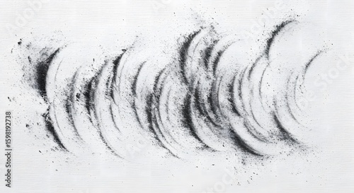 Black dust trails create dynamic patterns on a white canvas surface