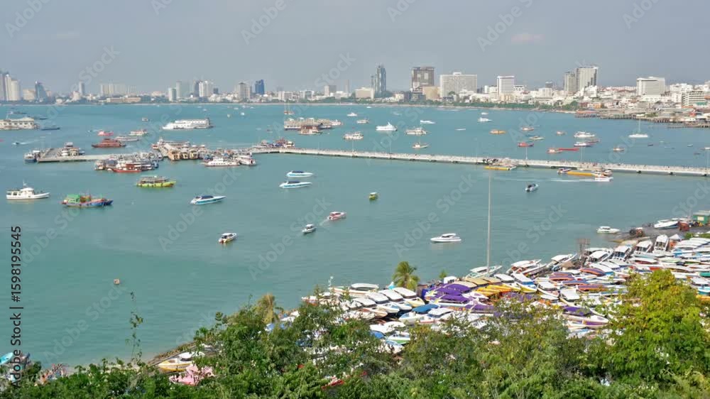 A vibrant cityscape of pattaya thailand overlooking a bay filled with boats