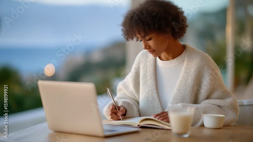 Optimize your morning routine with a bullet journal and laptop at sunrise for a productive start to your day.