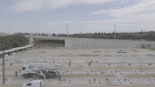 Wide shot of active construction site with workers and vehicles moving around. Concrete foundation works in progress at airport project in Turkey. Ideal for construction, industry, and infrastructure 