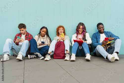 Happy friends using cell phones and social media - Students sitting in university campus using app on the smartphones