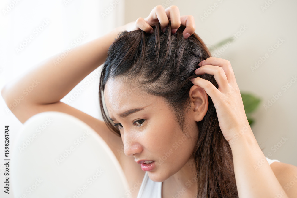 Fototapeta premium Young woman scratching her head feeling itch from dermatology problem