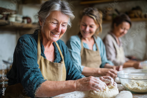 Generations of women baking bread in rustic kitchen, mixing dough and smiling, 