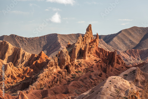 Majestic red rock formations dominate the landscape of Charyn Canyon, Kazakhstan.  A stunning natural wonder showcasing the power of erosion, creating intricate geological structures under a vast,