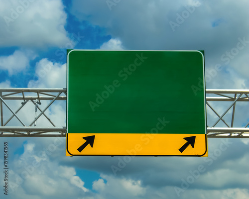 a green highway road sign with copy space isolated on a cloud background.  directional banner, and exit signs on interstates and local roads. abstract design element