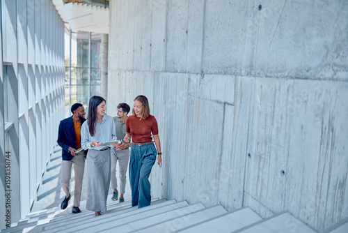 фотографія Group of multi-ethnic businesspeople discussing a project while going up the sta