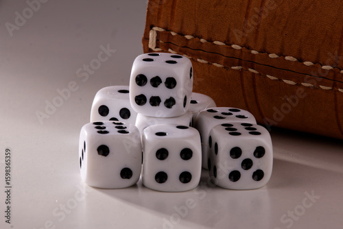 A random arrangement of dice and a puzzle cup, captured after the dice have been cast.