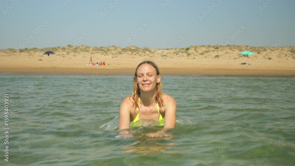 Blonde woman walking from sandy shore into turquoise waters, experiencing carefree summer bliss during tropical beach vacation. Lifestyle, vacation, tourism,nature, active life Blonde woman walking from sandy shore into turquoise waters, experiencing carefree summer bliss during tropical beach vacation. Lifestyle, vacation, tourism,nature, active life