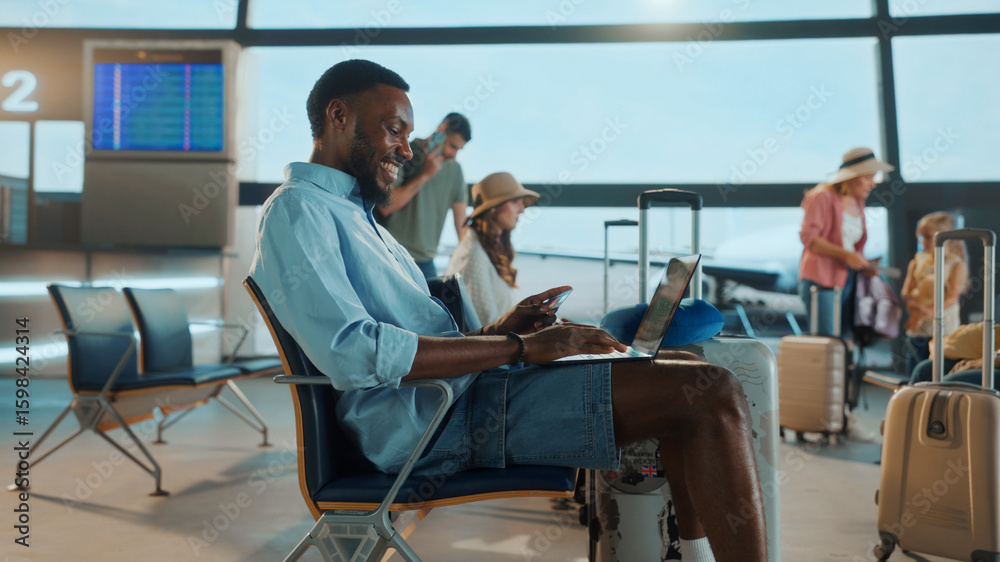 Fototapeta premium Happy tourist using laptop in airport lounge while waiting for flight departure