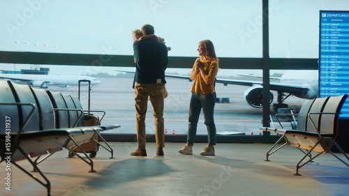Foto Emotional family reunion at airport gate as parents kneel to hug their daughter, with airplane visible through large windows — capturing love, travel, and heartfelt moments of arrival or farewell