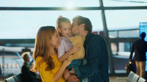 Bild auf Leinwand Happy family reunites at the airport, parents embracing their young daughter with smiles and warmth — capturing love, travel, and emotional connection in a joyful moment of arrival or departure