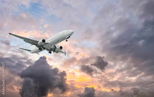Airplane flying in beautiful sky with clouds at sunset