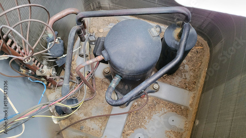 Air conditioner and heat pump compressor, accumulator receiver and refrigerant copper pipes, valves, fittings and wiring inside of outdoor HVAC unit, close up