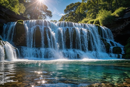 Breathtaking Waterfall with Cascading Water Flowing into a Clear Pool Under Bright Sunshine