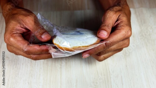 A person uses both hands to open a cake in a plastic container.
4k 50 fps.