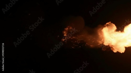 Powerful fiery blast erupting against a pitch black night sky bright orange yellow flame jet of intense burning heat energy and inferno hot fire shooting right 