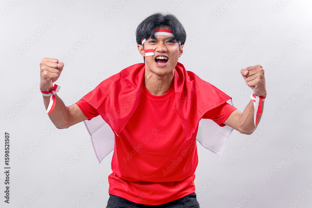 Naklejka premium Determined young man in red shirt and Indonesian flag cape, clenching fists and shouting with spirit, celebrating independence day with pride, passion, and full of national energy!