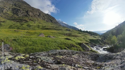 Timelapsw Zeitraffer Szene Wolkenspiel bei blauem Himmel im Tal von Bergen in Südtirol in Lazins Texelgruppe mit einem Wildbach Var. 1