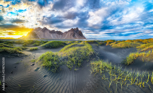 Fototapeta Naklejka Na Ścianę i Meble -  Impressive sunset with gorgeous black sand dunes on Stokksnes cape in Iceland.