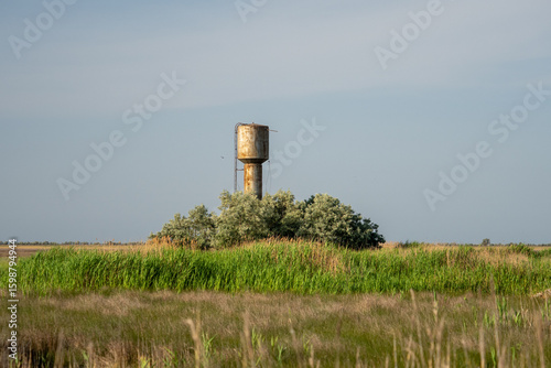 Rusty water tower in wild grassland on Dzharylhach Island, Ukraine