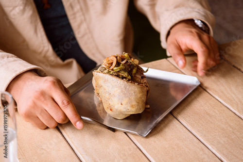 unrecognizable man eating steak burrito