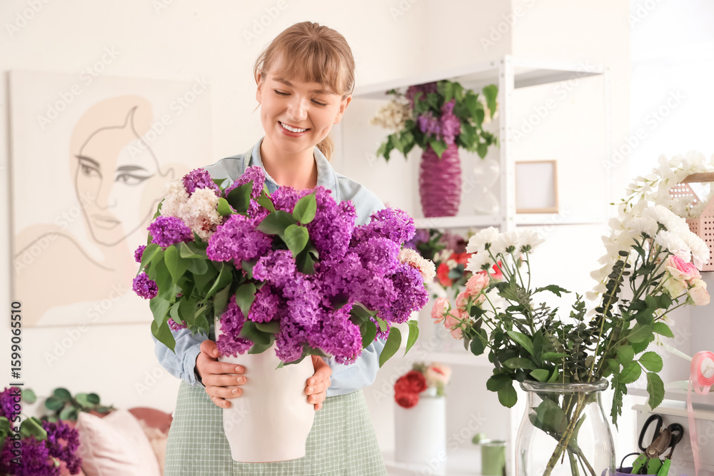 Female florist with vase of lilacs in flower studio Female florist with vase of lilacs in flower studio