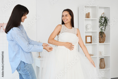 Happy young woman trying on...