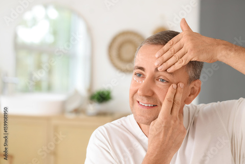 Happy mature man doing face...