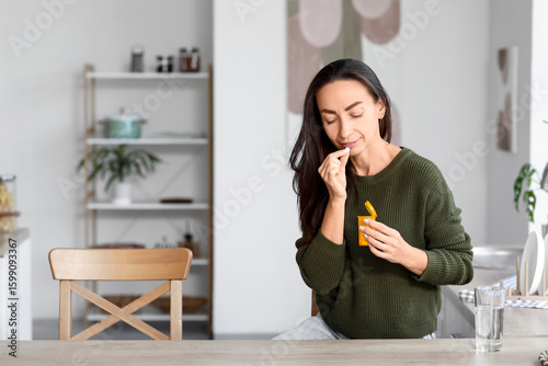 Beautiful woman taking pill...