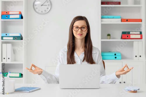 Young businesswoman meditat...
