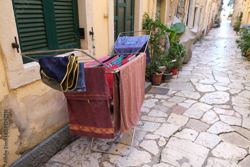 Fototapeta Naklejka Na Ścianę i Meble -  Laundry drying on a rack in a cobbled alleyway in Corfu during the day