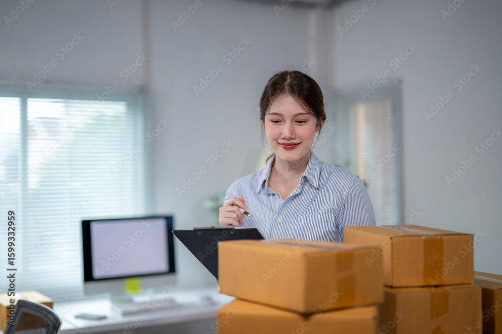 Asian female entrepreneur checking packages in home office Asian female entrepreneur checking packages in home office
