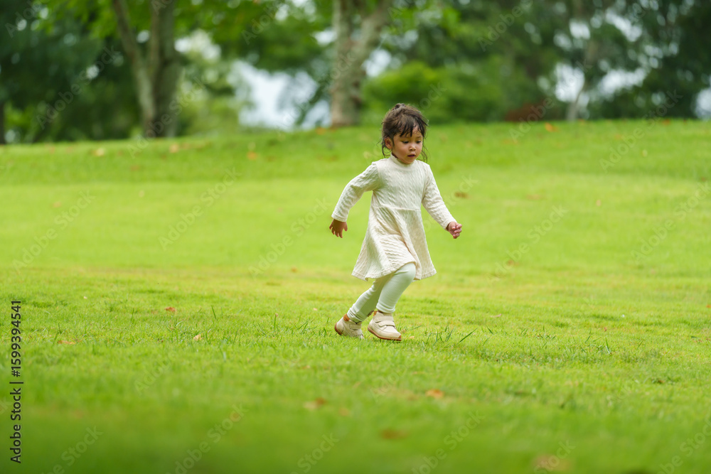 happy toddle girl in white dress running on green grass field happy toddle girl in white dress running on green grass field