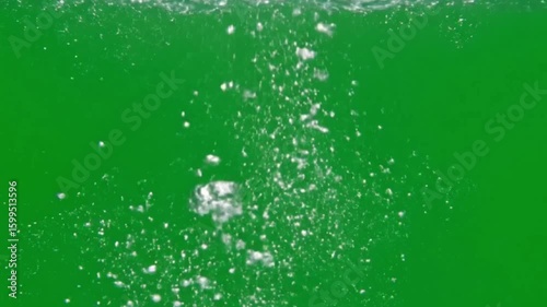 Bubbles rise in bright green liquid creating a dynamic effervescent effect with varying sizes and density