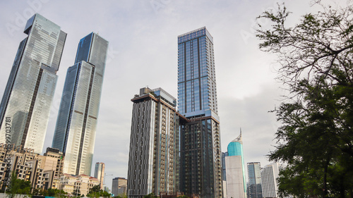 view of a public park with a lake in Jakarta in the morning with a background of modern buildings on the lake side