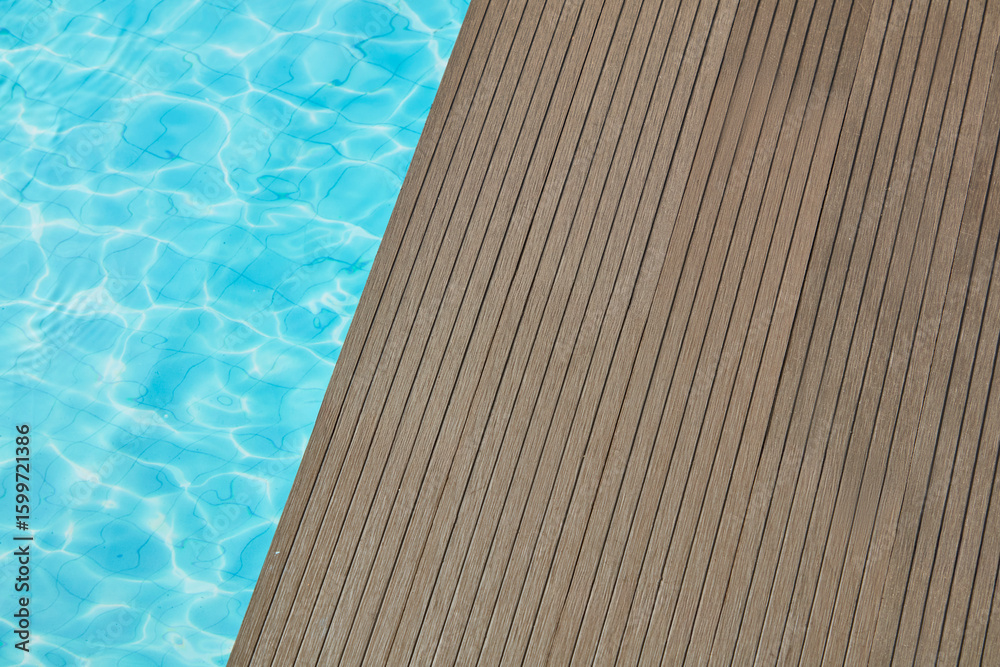 Obraz premium Minimal summer poolside with wooden deck and clear blue water, offering a clean and simple backdrop for product displays or lifestyle themes.