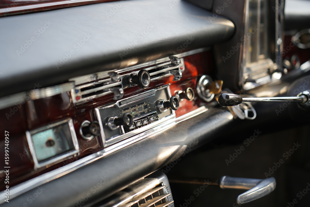 Naklejka premium The dashboard of a vintage classic car features detailed analog gauges, a radio, and air vents in polished wood and chrome, offering a fresh yet luxurious look.