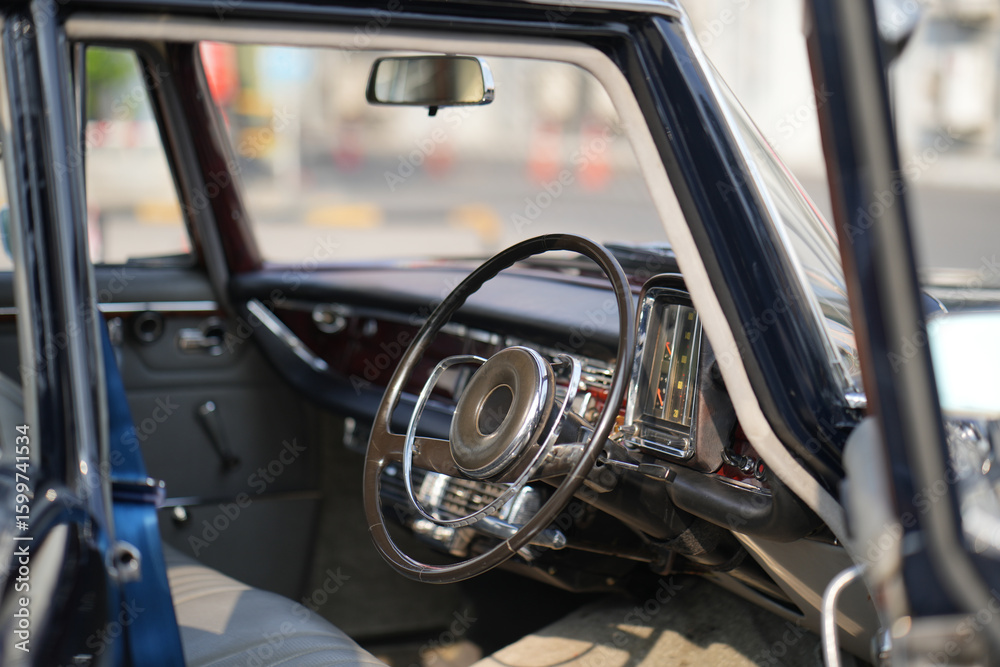 Obraz premium Vintage Classic car steering wheel, with chrome and leather textures in sharp detail, showcases the quality and precision of automotive craftsmanship under natural light.