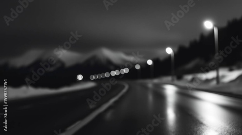 Monochrome evening cityscape with defocused lights and mountain backdrop