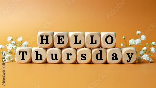 Wooden blocks spelling Hello Thursday,  pastel orange background, delicate white flowers.