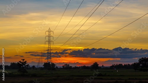 Timelapse of Sunset in the middle of a rice field with high-voltage electric poles