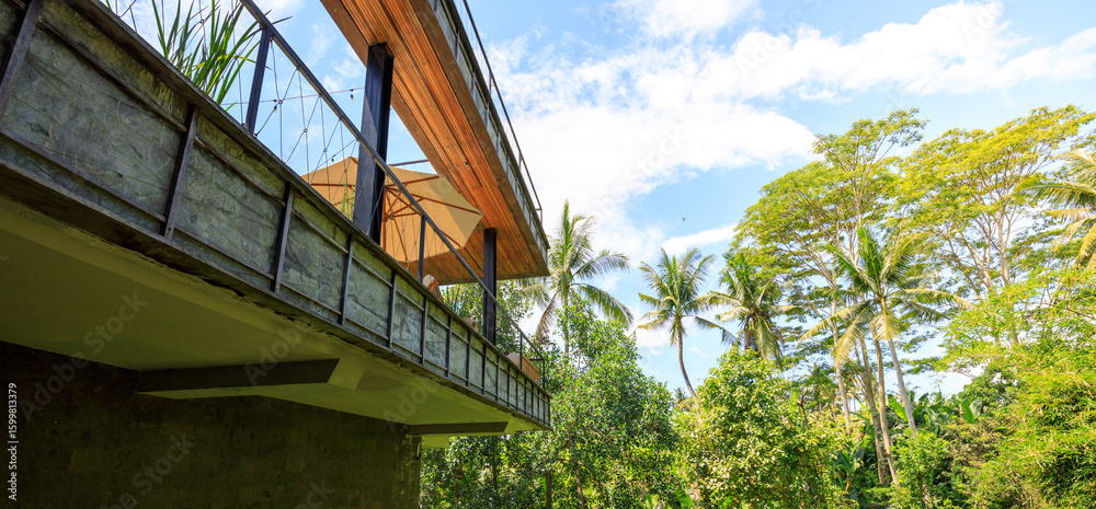 Fototapeta premium A wooden balcony with a tan roof and a view of trees