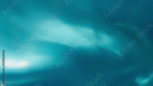 A smooth, flowing blue fabric mimics ocean waves, illuminated by soft light that enhances its dynamic, wavy patterns. 