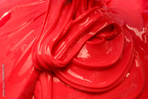 A close up of a red slime with a glossy swirl pattern, featuring smooth curves and a shiny surface. Perfect for backgrounds, advertising, textures, or food and beauty product visuals