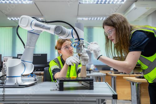 Two people are working on a robot. Concept of Industry 4.0 with diverse engineers collaborating on automation technology.