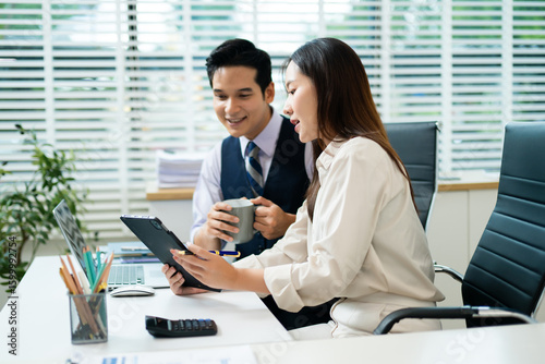 Professional team collaborating in office, using tablet and laptop, with coffee in hand showcasing modern workplace culture, productivity